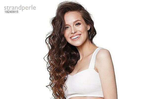 Schönes junges Mädchen in weißem Kleid mit natürlichem Make-up  Haarlocken und Lächeln. Schönheit Gesicht