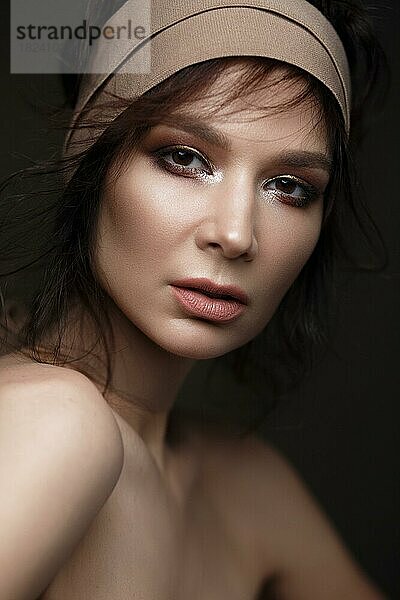 Schöne Frau mit einem hellen Make-up und perfekter Haut. Schönes Gesicht. Bild im Studio auf einem schwarzen Hintergrund genommen