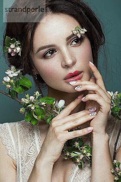 Schöne brünette Mädchen in Dessous mit einem sanften romantischen Make-up  rosa Lippen  hält Blumen. Die Schönheit des Gesichts. Porträtaufnahme im Studio