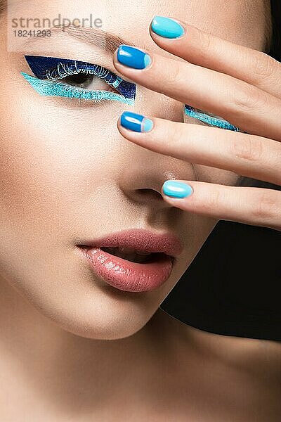 Schönes Mädchen mit hellen kreativen Mode Make-up und blauen Nagellack. Kunst Schönheit Nageldesign. Bild im Studio aufgenommen