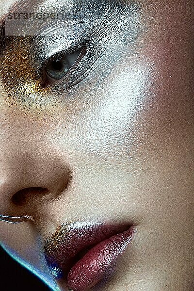 Schönes Mädchen mit kreativen goldenen und silbernen Glitzer-Make-up. Die Schönheit des Gesichts. Fotos im Studio geschossen