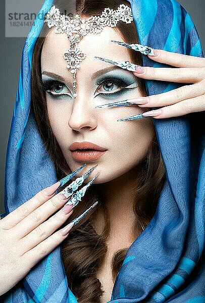 Schönes Mädchen im östlichen Arabisch Bild mit langen Nägeln und hellblau Make-up. Bild im Studio auf einem grauen Hintergrund genommen