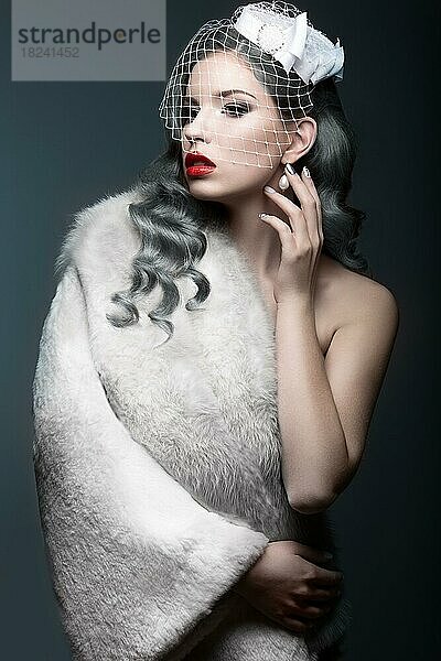 Elegantes schönes Mädchen mit silbernen Locken und einem Schleier. Bild Winter. Schönheit Gesicht. Bild im Studio auf einem grauen Hintergrund genommen