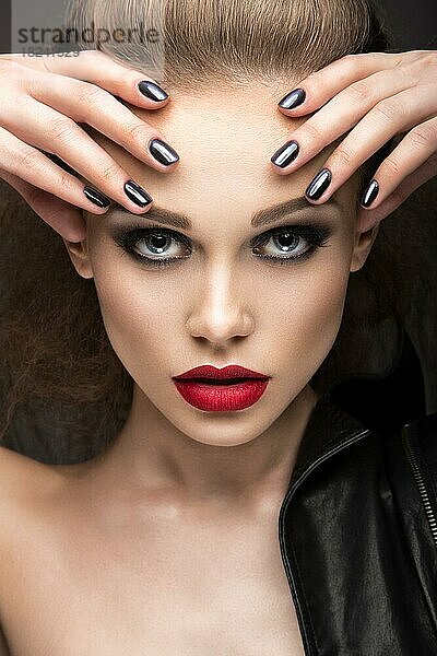 Schönes Mädchen in Lederjacke mit hellen Make-up und Maniküre Cat's Eye. Schönheit Gesicht. Nageldesign. Bild im Studio auf einem schwarzen Hintergrund aufgenommen