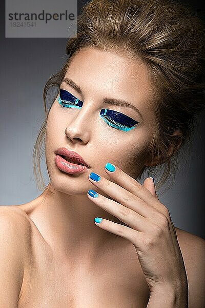 Schönes Mädchen mit hellen kreativen Mode Make-up und blauen Nagellack. Kunst Schönheit Nageldesign. Bild im Studio aufgenommen