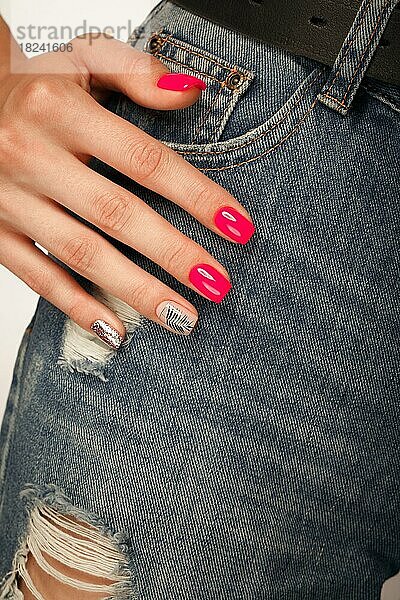 Helle Neon Maniküre auf weiblichen Händen auf dem Hintergrund der Jeans. Nageldesign. Schönheit Hände