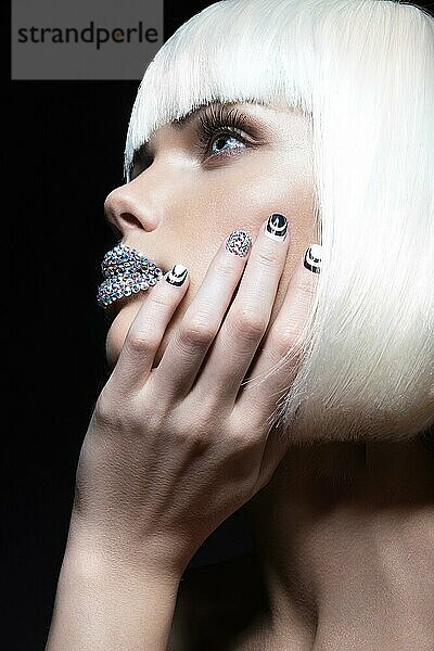 Elegantes schönes Mädchen in einer weißen Perücke  mit den Lippen aus Strass und festlicher Maniküre. Schönheit Gesicht. Bild im Studio auf einem schwarzen Hintergrund genommen