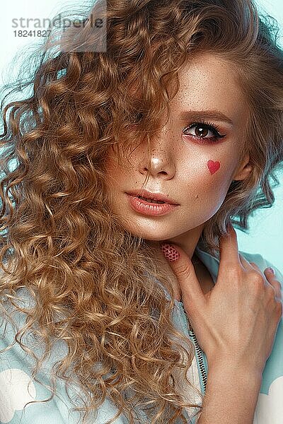 Hübsches Mädchen mit Lockenfrisur  klassischem Make-up  Sommersprossen  nackten Lippen und Maniküre-Design. Schönes Gesicht. Kunst Nägel. Studio Porträt