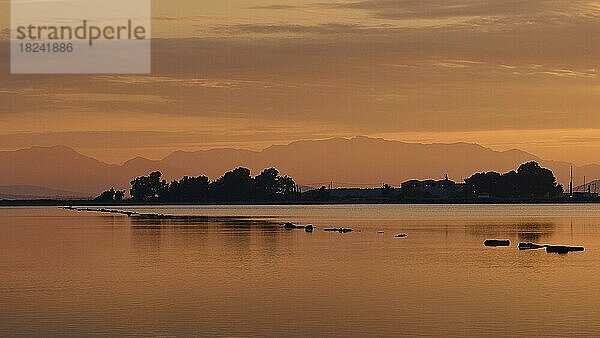 Sonnenaufgang  Morgendämmerung  Morgenlicht  Lagune  spiegelglattes Meer  Baumgruppe als Schattenriss  Berge auf dem Festland  Lefkada-Stadt  Hauptstadt der Insel  Insel Lefkada  Lefkas  Ionische Inseln  Griechenland  Europa