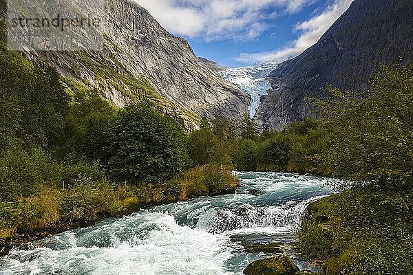 Blick über einen reisenden Fluss zum Gletscher Briksdalsbreen in Norwegen