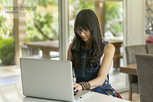 Geschäftsfrau  die von zu Hause aus arbeitet und auf ihren Laptop schaut