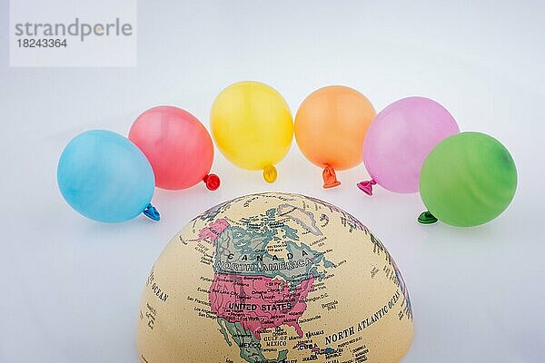 Farbige Luftballons werden um die halbe Weltkugel gelegt