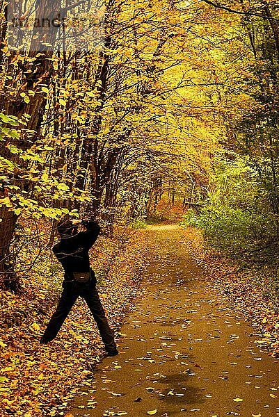 Fotograf fotografiert Herbstlandschaft an einer Straße