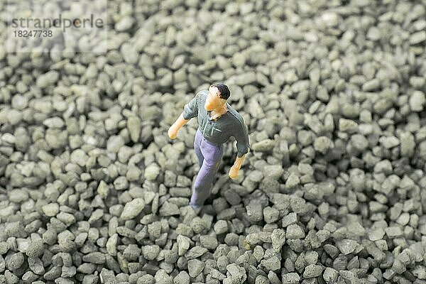 Winzige Figur von Mann Miniatur in grünem Sand Textur