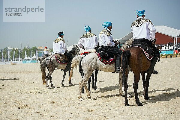 Reiter in ihrer ethnischen Kleidung auf dem Pferderücken