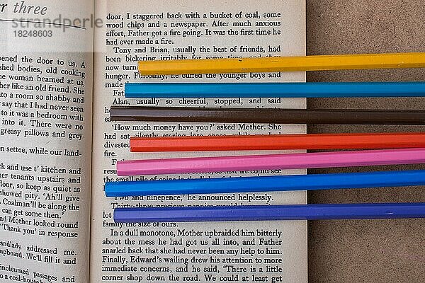 Buntstifte auf der Seite eines Buches mit Text