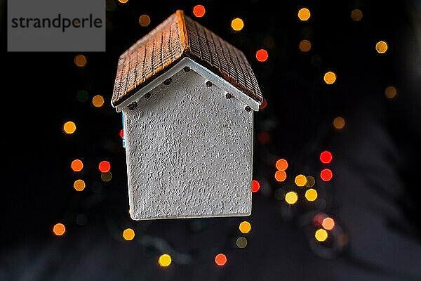 Kleines Modellhaus auf einem Bokeh-Licht vor einem dunklen Hintergrund