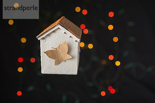 Papier Schmetterling auf einem Modell Haus auf einem Bokeh Licht