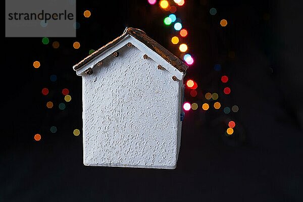 Kleines Modellhaus auf einem Bokeh-Licht vor einem dunklen Hintergrund