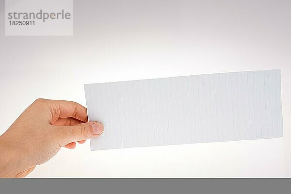 Hand hält ein Stück Papier auf einem weißen Hintergrund