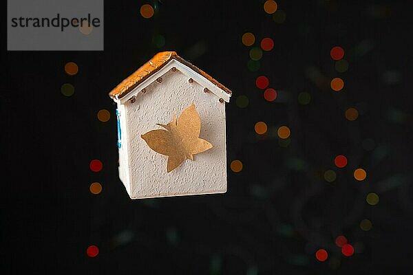 Papier Schmetterling auf einem Modell Haus auf einem Bokeh Licht