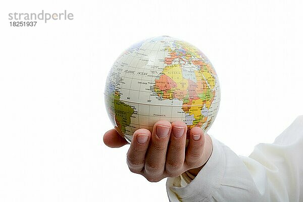 Kind hält einen kleinen Globus in der Hand auf weißem Hintergrund