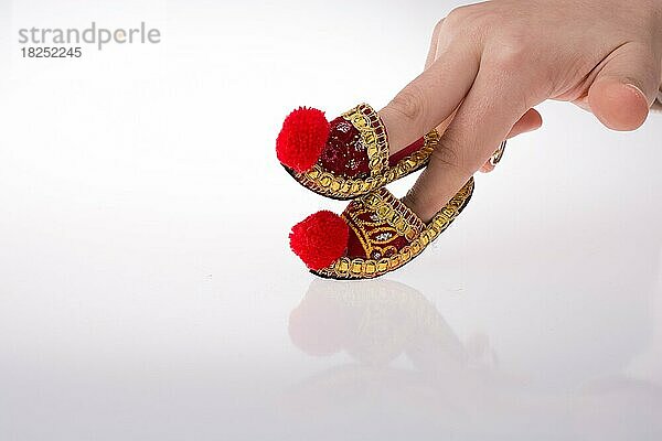 Hand hält traditionelle türkische handgefertigte Schuhe auf weißem Hintergrund
