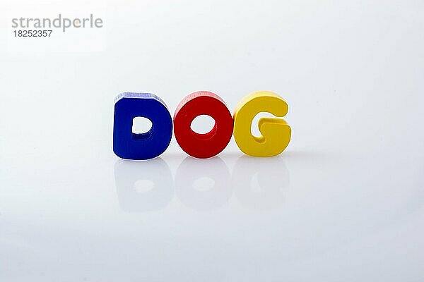 Das Wort DOG geschrieben mit bunten Buchstabenblöcken auf weiß