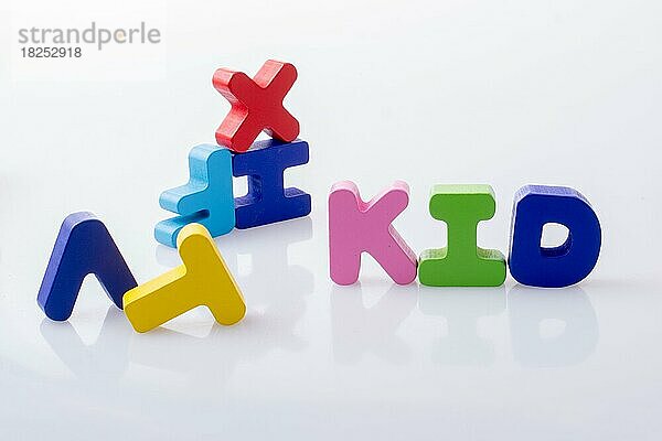Das Wort KID geschrieben mit bunten Buchstabenblöcken auf weißem Grund