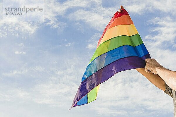 Mann mit großer Flagge lgbt Farben blauer Himmel  Auflösung und hohe Qualität schönes Foto