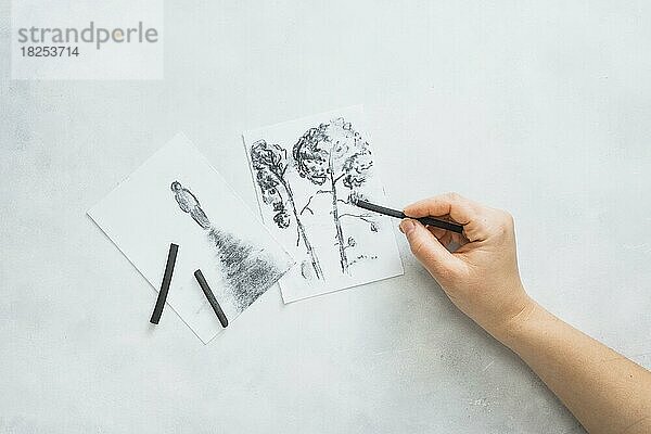 Person s Hand skizzieren schöne Zeichnung mit Holzkohle-Stick weiße Oberfläche  Auflösung und hohe Qualität schönes Foto