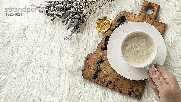 Draufsicht Person hält Tasse Kaffee mit Lavendel getrocknete Zitrusfrüchte. Auflösung und hohe Qualität schönes Foto