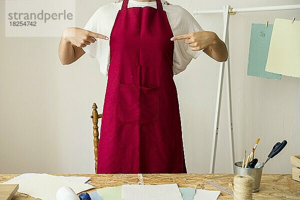 Frau zeigt auf ihre rote Schürze. Auflösung und hohe Qualität schönes Foto