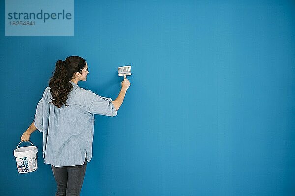 Frau malt blaue Wand. Auflösung und hohe Qualität schönes Foto