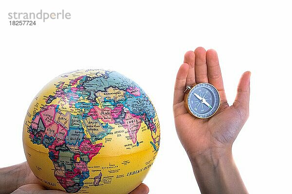 Globus und Kompass in der Hand auf weißem Hintergrund