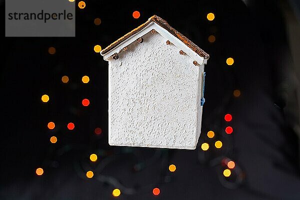 Kleines Modellhaus auf einem Bokeh-Licht vor einem dunklen Hintergrund