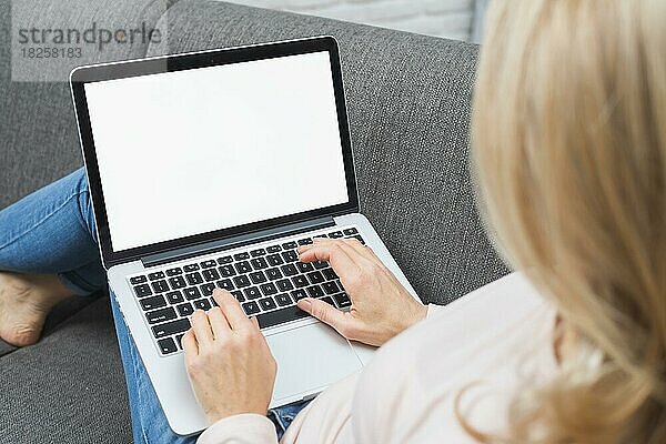 Close up blonde Frau sitzt Sofa mit Laptop mit leeren weißen Bildschirm