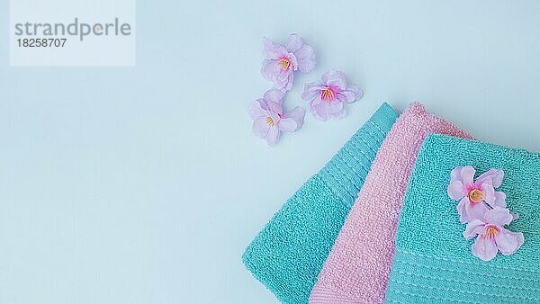 Erhöhte Ansicht Handtücher mit lila Blumen blauen Hintergrund