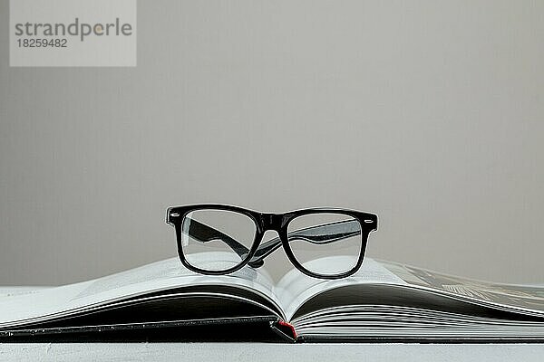 Vorderansicht offenes Buch mit Brille