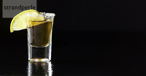 Vorderansicht Gold Tequila Shot mit Limette Kopie Raum