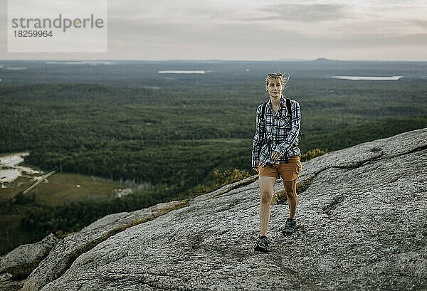 Junge Frau in kariertem Hemd und Rucksack wandert Schoodic Mountain  Maine
