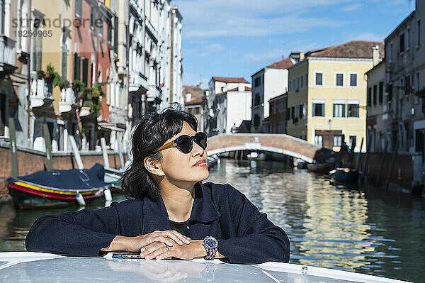 Frau genießt eine Bootstaxifahrt in Venedig