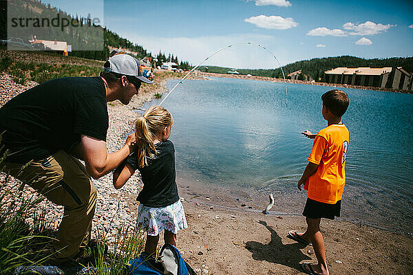 Familie fängt im Abenteuerurlaub einen Fisch aus einem Bergsee