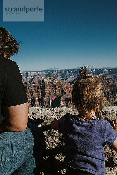 Vater der amerikanischen Ureinwohner und kleine Tochter schauen über das Gras