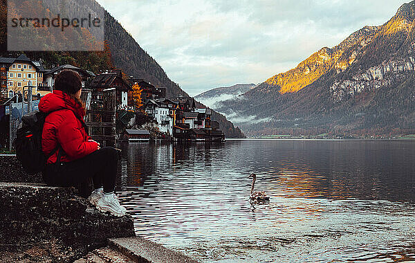 Frau sitzt und blickt auf das Panorama am See