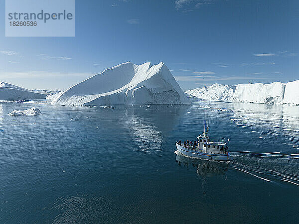 kleines Boot in der Nähe großer Eisberge aus der Luft