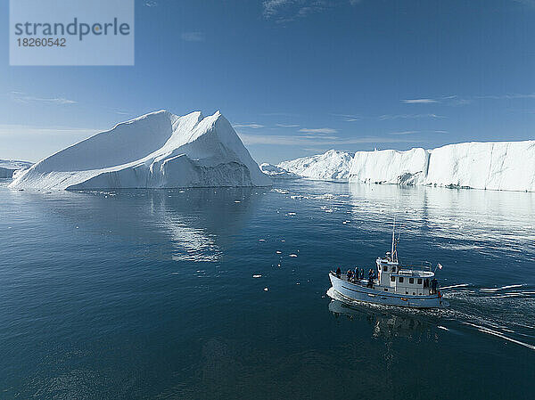 kleines Boot in der Nähe großer Eisberge aus der Luft