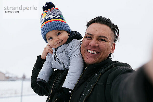 Vater und Sohn der amerikanischen Ureinwohner machen draußen gemeinsam ein Selfie