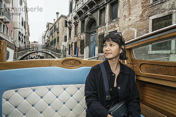 Modische Frau genießt eine Bootstaxifahrt in Venedig