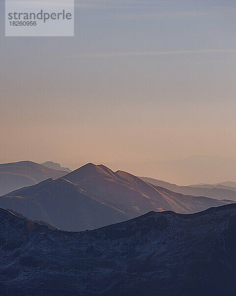 Herbstlicher violetter Sonnenuntergangsnebel über den kaukasischen Bergen